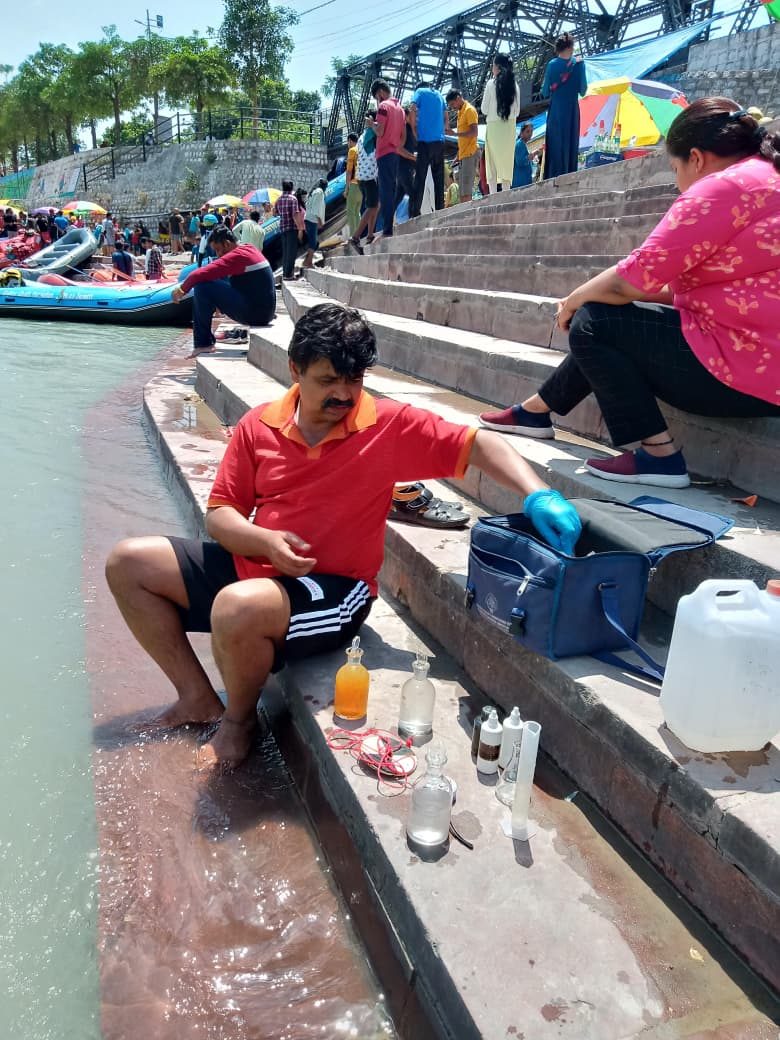 A man sets out water sample bottles on river ghat steps
